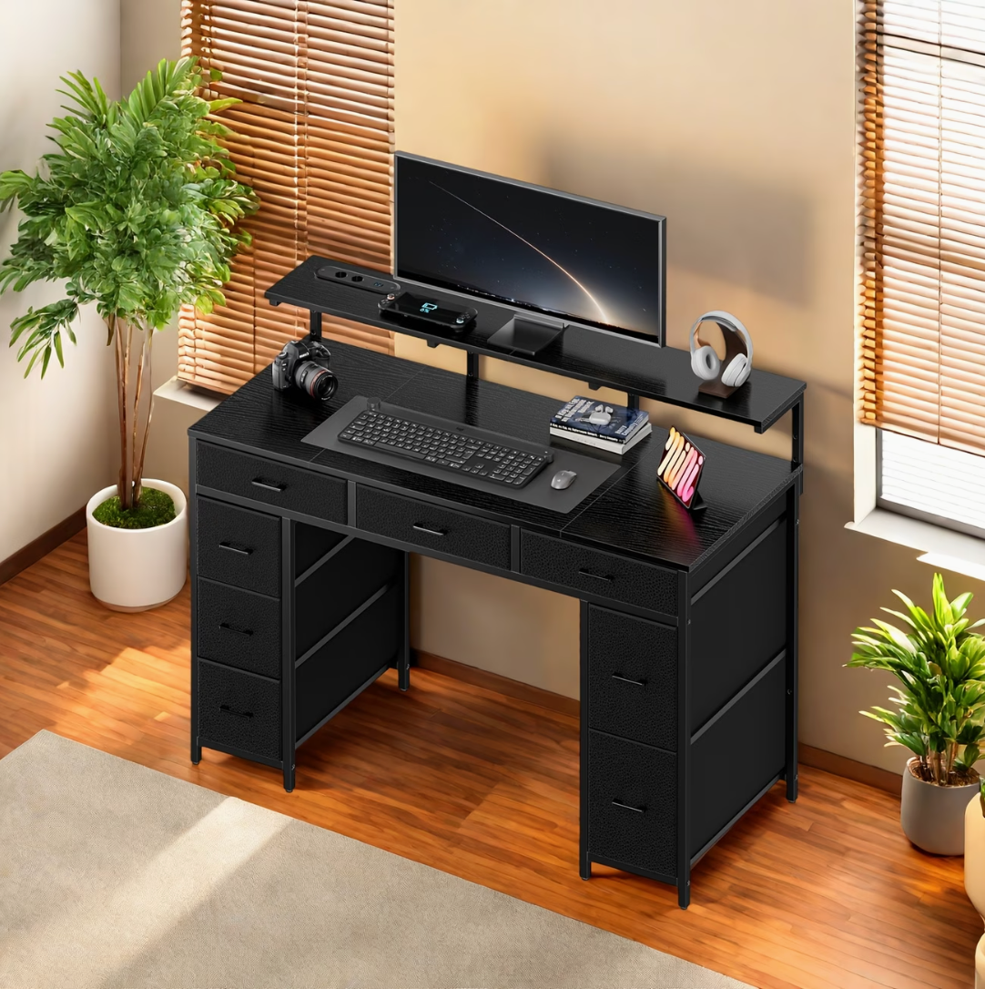 Bureau noir 8 tiroirs installé dans une pièce de travail avec écran et rangements